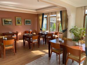 a restaurant with tables and chairs and windows at Sarikonaklar Garden Village in Sile