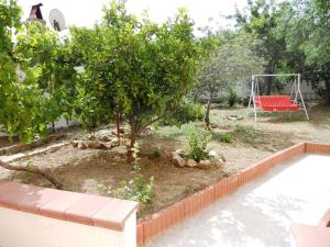 un jardín con un banco rojo y un columpio en Apartment Da Mario, en Santa María