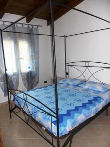 1 dormitorio con cama de metal y edredón azul en Apartment Da Mario, en Santa María