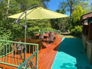 a deck with a table and an umbrella next to a pool at Sarikonaklar Garden Village in Sile