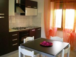 cocina con mesa negra y sillas blancas en Apartment Da Mario, en Santa María