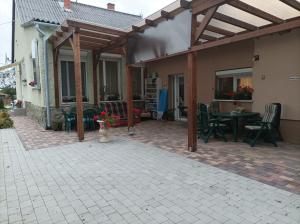 a covered patio with a fire in the back of a house at Csilla Apartman in Balogunyom