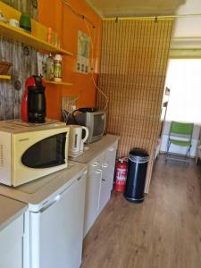 a kitchen with a microwave on top of a counter at Ferienbungalow Tinka in Štúrovo