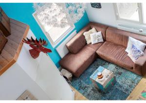 sala de estar con sofá de cuero marrón en B&B - Pension Perruque en Koudum