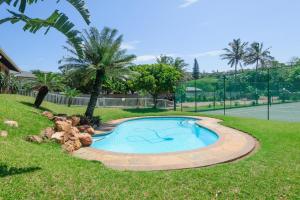 a swimming pool in a yard with a tennis court at Beachfront @ Driftwood 6 Luxury Family Apartment in Ballito