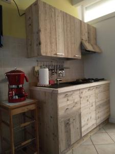 a kitchen with wooden cabinets and a red mixer at DA BRUNA in Rovetta
