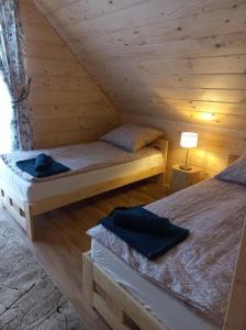 a bedroom with two beds in a log cabin at Domek na Hubce II in Maniowy