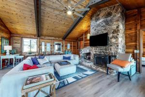 uma sala de estar com uma lareira de pedra e um sofá em Heron Haven em Bodega Bay