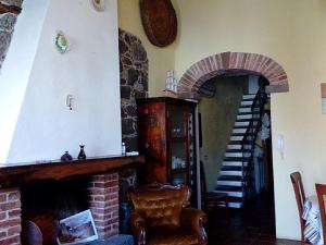 a living room with a brick fireplace and a staircase at Domus Maria in Milis