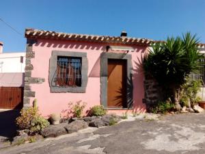 ein rosa Haus mit einem Fenster und einer Tür in der Unterkunft Domus Maria in Milis