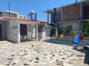 a backyard with an umbrella and a playground at Villas Apartments SHAHAJ in Vlorë