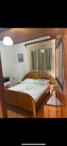 a bedroom with a large bed with a window at Villas Apartments SHAHAJ in Vlorë