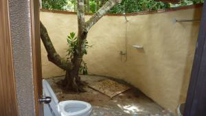 a bathroom with a tree next to a toilet at Baandin Chiewlarn in Ban Ta Khun