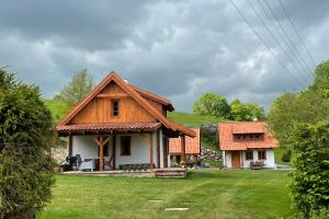 dom z dachem krytym strzechą na dziedzińcu w obiekcie Domy w Lipowie - dom żółty w mieście Piecki