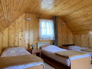 een slaapkamer met 2 bedden in een houten hut bij Vikendica Klara in Žabljak