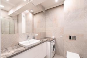 a bathroom with a sink and a washing machine at Apartament Kochanowskiego z ogródkiem i garażem - Dream Apart in Ustroń +11 photos