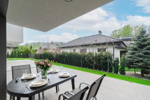a table and chairs on the patio of a house at Apartament Kochanowskiego z ogródkiem i garażem - Dream Apart in Ustroń