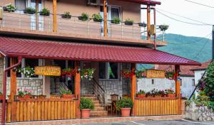 un edificio con flores en la parte delantera en Restoran & Motel Manjež, en Bijelo Polje