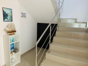 a staircase in a home with white walls and white floors at Vila Ardealul in Mangalia