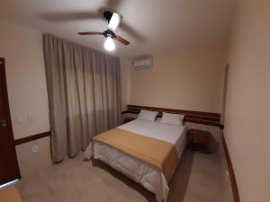 a bedroom with a bed and a ceiling fan at Pousada dos Pássaros in Quartéis +18 photos