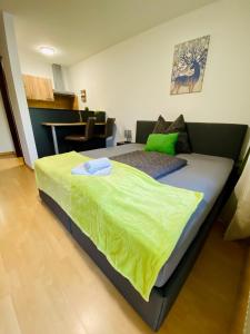 a bedroom with a bed with a green blanket on it at Apartment Dachstein nahe Zentrum in Bad Ischl