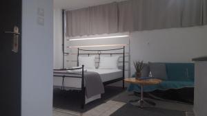 Studio V3st & Parking في لاريسا: غرفة نوم بسرير وطاولة واريكة