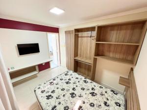 a small room with a bed and a tv at L'acqua diroma I, II, III, IV e V- Aptos in Caldas Novas