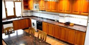 a kitchen with wooden cabinets and a black counter top at La Eria de Villaverde in Intriago