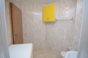 a bathroom with a yellow cabinet and a toilet at Vrnjački borovi 2 in Vrnjačka Banja