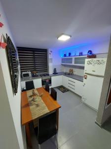 a kitchen with a wooden table and a refrigerator at AN golden suite in Eilat