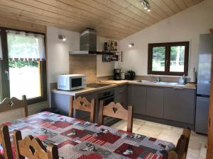 a kitchen with a table and a microwave in it at Chalet CHLOE - jusque 6 pers - Xonrupt Longemer in Xonrupt-Longemer