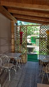un patio con mesa y sillas y una pared con una valla en Locanda La Tana Del Luppolo en Valmadrera