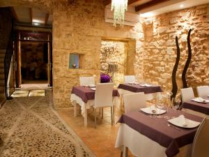 a restaurant with tables and chairs in a stone wall at Ca´n Pere in Alcudia