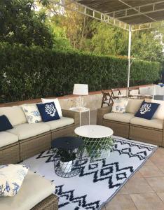um pátio com sofás, uma mesa e um tapete em Villa Nina em Fontane Bianche