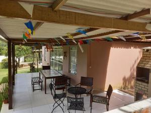um pátio com uma mesa, cadeiras e bandeiras em CASA DA SERRA na Chácara Paraíso em Bananeiras