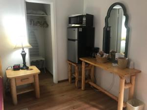 a room with a table and a mirror and a refrigerator at Dunsmuir Lodge in Dunsmuir