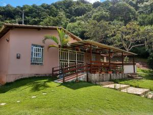 a house with a porch and a grass yard at CASA DA SERRA na Chácara Paraíso in Bananeiras