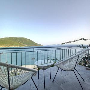 a balcony with a table and chairs and the ocean at Ponti Bay Apartments in Vasiliki