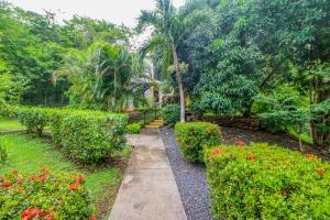 a walkway through a garden with flowers and trees at Dulce La Colina 8002 in Coco