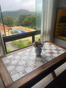 貝澤羅斯的住宿－flat em serra negra - bezerros，窗前桌子上的花瓶