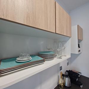 a kitchen with plates and glasses on a shelf at Ponti Bay Apartments in Vasiliki