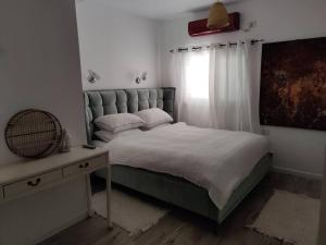 une chambre avec un grand lit et une fenêtre dans l'établissement פינה בוואדי / A corner in the valley, à Ani'am 28 autres photos