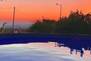 une piscine d'eau avec un coucher de soleil en arrière-plan dans l'établissement פינה בוואדי / A corner in the valley, à Ani'am