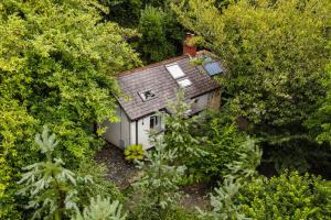 una vista aérea de una pequeña casa rodeada de árboles en Beili Glas Cottage, en Pontardawe