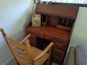 Elle comprend un bureau en bois avec une chaise et un piano. dans l'établissement Natuurlijk leuk, à Sterksel