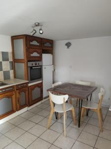 uma cozinha com uma mesa e cadeiras e um frigorífico em Appartement T2 Roquebrune sur Argens em Roquebrune-sur-Argens