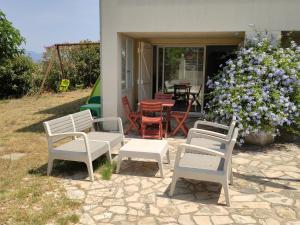 um grupo de cadeiras e uma mesa e um arbusto com flores em Appartement T2 Roquebrune sur Argens em Roquebrune-sur-Argens