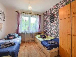 a bedroom with two twin beds and a window at Apartament Wrzos Bieszczady in Czarna