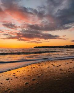 a sunset on a beach with the ocean at Ohana B&B in Marina di Camerota