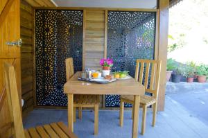 a wooden table with two chairs on a patio at BEC ROZ' in Salazie